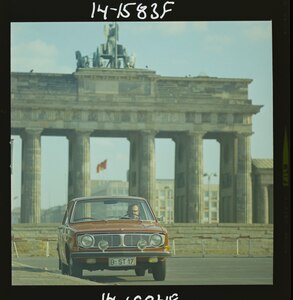 En röd Volvo 144 framför Brandenburger Tor 1967.