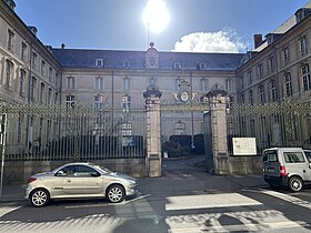 Entrée du siège de la bibliothèque municipale, à la Bibliothèque Stanislas : grilles sur rue, bâtiment en "U" et cour intérieure paysagée.