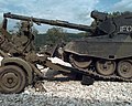 A Danish Leopard 1 preparing to drive over and crush a Serbian Zastava M55 anti-air gun