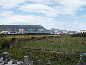 屋島を背にして春日川を渡る 1000形気動車による高徳線の普通列車