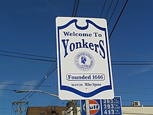 White-and-blue street sign against a blue sky