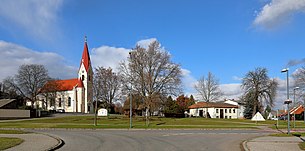 Ortszentrum mit röm.-kath. Pfarrkirche. Davor eine Grünanlage mit dem Kriegerdenkmal