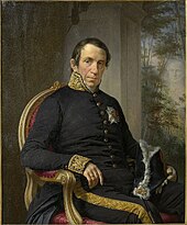 Le Baron Louis de Schiervel portant des vêtements militaires pose assis.