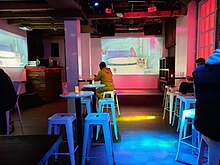 Photo of the interior of a bar with pink lighting