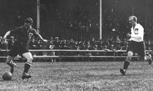 Photographie en noir et blanc d'une scène d'un match de football.