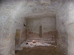 Photographie en couleurs d'une pièce d'habitation creusée dans le roc.