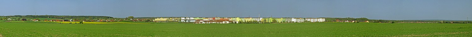 Panorama miasta od strony zachodniej. Patrząc od lewej strony kolejno widzimy osiedle Warzyń Stary, Warzyń Nowy (Kompleks Hotelowo-Sportowy Rokita, pływalnia Aquasport, Liceum Ogólnokształcące im. J.M. Ossolińskiego, a w głębi kominy zakładów chemicznych PCC Rokita) oraz Stare Miasto. Na fotografii nie widać dalszych dzielnic miasta – osiedla Fabrycznego i osiedla Kręsko.