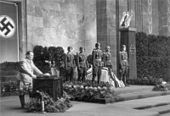 A black-and-white photo of six soldiers standing around a flag-covered coffin.