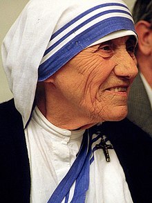 An image of Mother Teresa wearing a white head covering with blue stripes