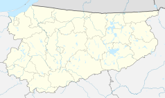 Mapa konturowa województwa warmińsko-mazurskiego, blisko centrum na prawo u góry znajduje się punkt z opisem „Strzelce”