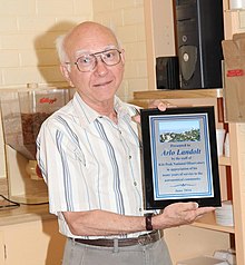 Photo of Landolt holding an award in 2014