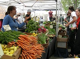 Vendedora de vegetais num mercado.