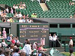 Le soir du deuxième jour, sur le court n° 16 où se joue un match de double dames, les spectateurs regardent un écran qui affiche le score du match Isner-Mahut (51-50, 8 h 53 de match).