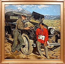 White man and Native American man leaning against a car with an open hood