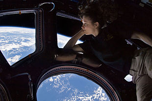 صورة مُلتقطة ذاتيًّا لرائدة الفضاء الأمريكية تريسي كالدويل دايسون وهي تشاهد الأرض عبر مركبة كوبولا الملتحمة بمحطة الفضاء الدولية ضمن البعثة الرابعة والعشرين