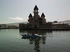 Замок в парке, стоящий на искусственном озере