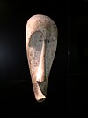 Masque attribué à la société du Ngil . M’fan ou Makina (Oseba). Fleuve Mbini (Rio Muni), XIXe siècle. Bois, kaolin, 75 × 29 × 19 cm[40]