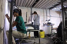 Technicians at work using laser scraping techniques in the sala delle asse