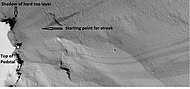 Dark slope streaks near the top of a pedestal crater, as seen by HiRISE under the HiWish program. Note in the middle of the picture, one can see the track of a boulder that rolled down a slope.