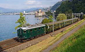 Train spécial SBB Historic devant le Château de Chillon ; en seconde position derrière la locomotive Re 4/4I 10001, une A vu II est intercalée entre trois voitures légères.