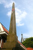 Banpaal in het dorp Sloten met daarop het wapen van Amsterdam en het jaartal 1794; op de achtergrond is de toren van de Sint-Pancratiuskerk