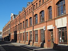 Three-storey, mostly brick building with glass windows.