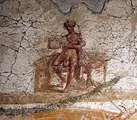 A nude male with an enlarged scrotum holding a scroll. Wall painting. Suburban baths, Pompeii. 62 to 79 CE