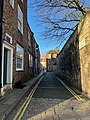 Looking west down the street from in front of number 1. The southern wall of Purey-Cust Lodge (right) is the only building on the northern side of the street