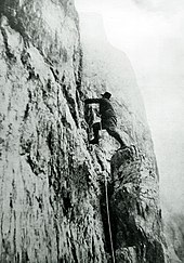 Le roi en tenue d'alpiniste escalade une paroi