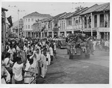 Civilians lining the city's streets to welcome British troops arriving on jeeps in 1945