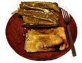 Tamales Oaxaqueños, large tamales willed with chicken and mole negro, wrapped in banana leaves and steamed.