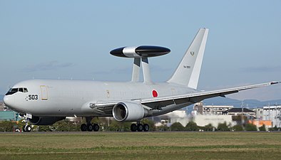 Vue latérale d'un avion de reconnaissance des forces armées japonaises sur une piste, avec un radar en forme de palet.