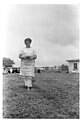 Photo en noir et blanc d'une femme habillée en blanc marchant dans l'herbe