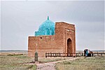 A brick mausoleum with a blue roof