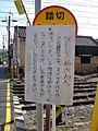 踏切の閉鎖時間が長いことをことわる看板。(2007年3月4日)