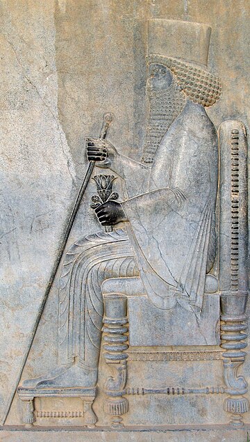 Relevo de Dario I em Persépolis. Dario I, foi um governante persa. Foi o terceiro Rei dos Reis do Império Aquemênida persa a partir de 522 a.C. e alegou ser o nono rei da dinastia aquemênida. Ao lado do fundador do império, Ciro, o Grande, Dario I é considerado o mais importante grande rei do antigo Império Persa. Na história do Império Aquemênida, o reinado de Dario foi o período de maior expansão do império. Ele também promoveu as artes, especialmente a arquitetura. A fundação de Persépolis e a atividade de construção em outras cidades residenciais, especialmente Susa, são testemunhas disso. (definição 1 775 × 1 775)
