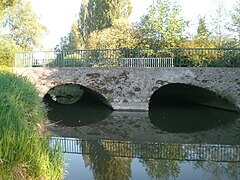 Pont à deux arches en pierre et béton au-dessus du contre fossé.