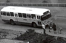 Photographie en noir et blanc d'un véhicule accueillant des passagers.