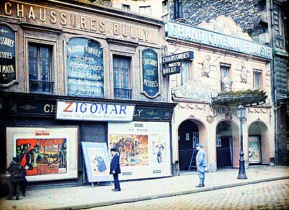 Durant la Grande Guerre, en 1917 ou 1918, des badauds (dont un soldat en uniforme bleu horizon) contemplent des affiches annonçant la ressortie de deux films Zigomar d'avant-guerre au « Grand Cinéma Plaisir » sis au 95 bis, rue de la Roquette à Paris 11e. Autochrome d'Auguste Léon[2],[3].