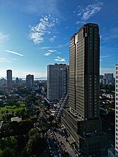 Aerial view of skyscrapers along a tree-lined street in the city,