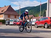 Woman bicycling through an alpine village