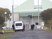 Image taken from afar of a number of prison staff members outside a gate of the HM Prison Barwon.