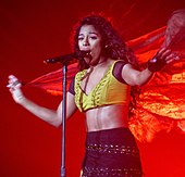 A picture of a woman singing at a concert.