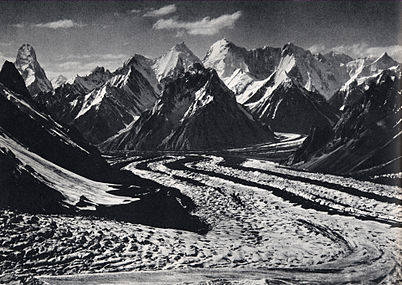 Vue depuis le haut du glacier du Baltoro[a] vers la tour de Mustagh (extrême gauche) et le Skil Brum (7 410 m, centre droit) ; cliquer sur la photo pour voir les étiquettes.