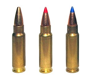 Tiga foto peluru 5,7 × 28 mm untuk olahraga menembak. The left cartridge has a plain hollow tip, the center cartridge has a red plastic V-max tip, and the right cartridge has a blue plastic V-max tip.