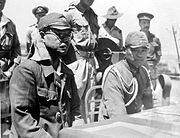 Kaida Tatsuichi, komandan Resimen Tank ke-4 Jepang, dan ketua staf-nya Shoji Minoru menyimak pernyataan kapitulasi dari HMAS Moresby di Timor.