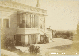 Photographie ancienne d'une villa avec façade moulurée et véranda.