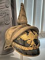 M1897 Pickelhaube, félig felhúzott M1892 sisakhuzattal (Überzug).