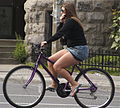 Una donna in bicicletta mentre indossa un maglione e una minigonna in Canada.