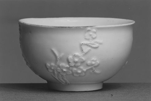 A cup made at Meissen Porcelain Manufactory, Germany, c. 1725–1730. Although long-known in China, the technique of making hard-paste porcelain was not developed in Europe until J. F. Böttger's experiments at Meissen in the early 18th century. This little porcelain cup with its applied prunus or plum blossom decoration reflects the influence of a Chinese, "Blanc de Chine" porcelain prototype.